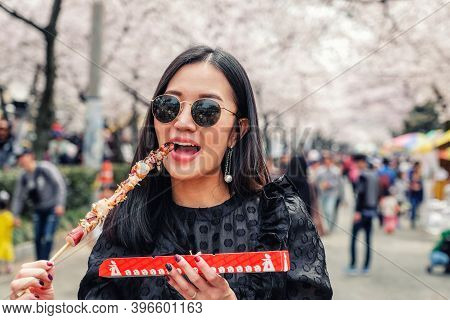 Young Woman Eating Steamed Octopus Legs At Jinhae Gunhangje Festival Street Food In Seoul, South Kor
