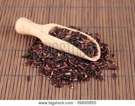 arroz preto com colher de madeira em esteira de bambu