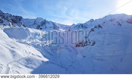 Snow Mountain Peaks With Rocks. View From Drone. In Places, You Can See Glaciers, Large Rocks And Ro