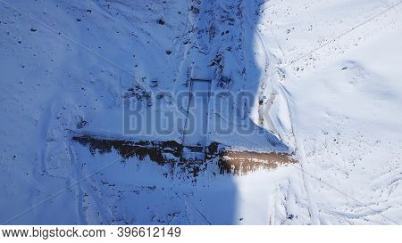 The Dam Was Covered With Snow In The Mountains. The View From The Top. The River Is Frozen, Everythi
