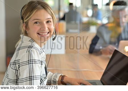 Portrait of office worker having a meeting online, headset on