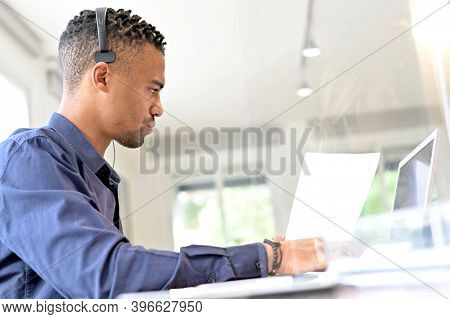 Office-worker with headset on, attending online business conference