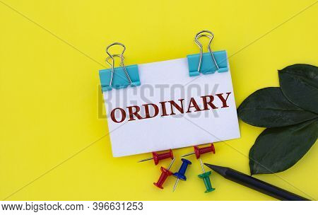 Ordinary - Word On A White Sheet With Clips On A Yellow Background With Buttons, A Green Sheet And A