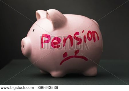 Ceramic Piggy Bank With Text On A Dark Background. Concept On The Topic Of Pension Reduction