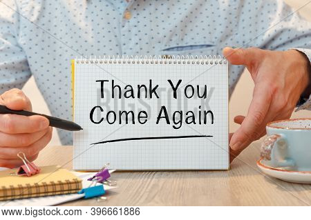 Notebook With The Text Thank You Come Again On The Office Table Among The Stationery.