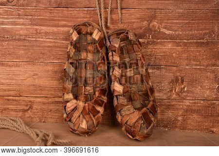 Birchen Woven Bast Shoes Hang On A Log Wall.