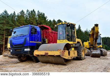 Dump Truck, Excavator, Dozer And Vibro Roller Soil Compactor At Road Construction And Bridge Project
