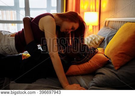 Cheerful Afro And European Lesbian Women At Home On The Bed