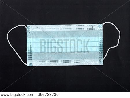 Protective Medical Mask Isolated On Black Background. Protection From Covid-19. Non-permanent Mask I
