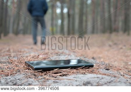 Young Man Loses His Smartphone On Russian Autumn Fir Wood Path. Carelessness And Losing Expensive Mo