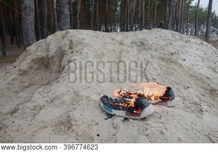 Burning Sports Sneakers Or Gym Shoes On Fire Stand On Sandy Beach Coast. Athlete Burned Out. Physica