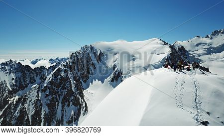 A Group Of Climbers Climb To The Top Of The Peak. Dangerous, Steep Slope. Avalanche-prone Area. Moun