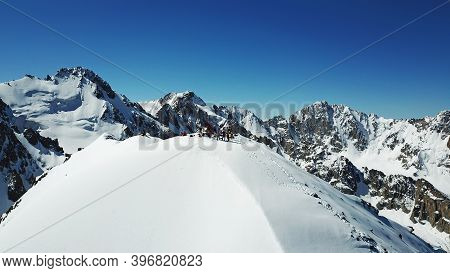 A Group Of Climbers Climb To The Top Of The Peak. Dangerous, Steep Slope. Avalanche-prone Area. Moun