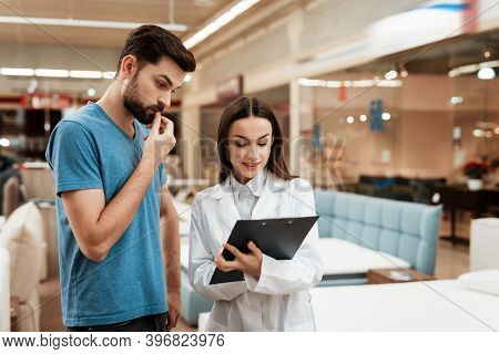 Lovely Woman Consultant With Confident Man Make Out Purchase Of Mattress In Store.