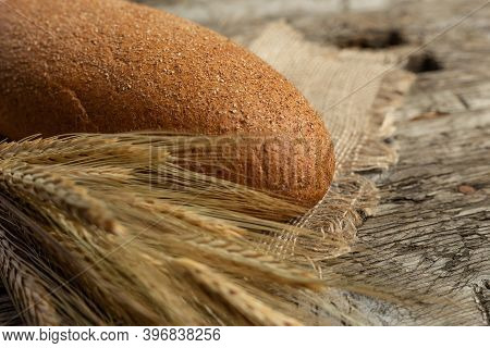 Freshly Baked Traditional Black Bread On A Wooden Table. Brown Coarse Bread Made From Shenitsa, Barl