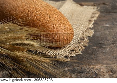 Freshly Baked Traditional Black Bread On A Wooden Table. Brown Coarse Bread Made From Shenitsa, Barl