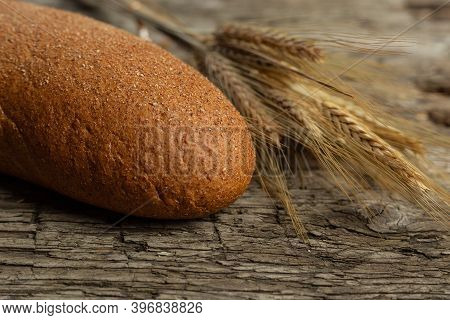 Freshly Baked Traditional Black Bread On A Wooden Table. Brown Coarse Bread Made From Shenitsa, Barl