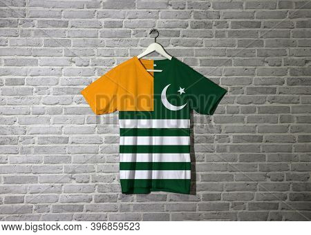 Azad Kashmir Flag On Shirt And Hanging On The Wall With Brick Pattern Wallpaper. Green Background Wi