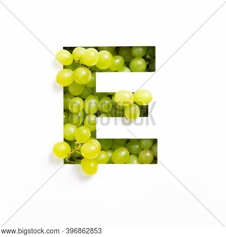 Letter E Of English Alphabet Of Green Grape And Cut Paper Isolated On White. Typeface Made Of Fresh 