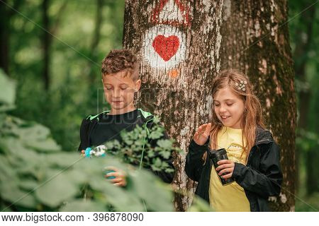 Little Boy And Cute Girl  In Forest Spending Great Time In Beautiful Spring Nature.