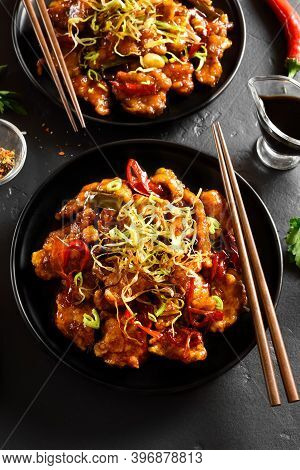 Spicy Garlic Fried Chicken (kkanpunggi). Asian Chicken In Sweet And Sour Sauce On Plate Over Black S