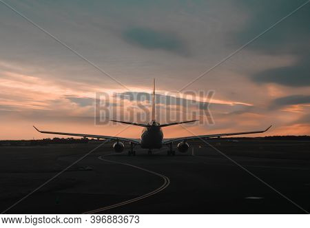 Sunset View Of An Airoplane On Airport Runway Under The Dramatic Sky In Prague Czech Republic. Aviat