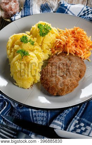 Homemade Minced Meat Cutlet Served With Mashed Potatoes And Carrot Salad.