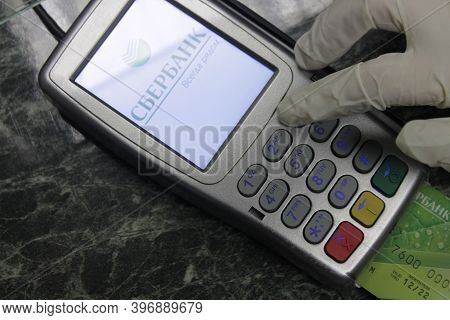 Sberbank Client Wearing Medical Gloves Enters A Password Into The Pinpad. Sberbank Is The Largest Mu