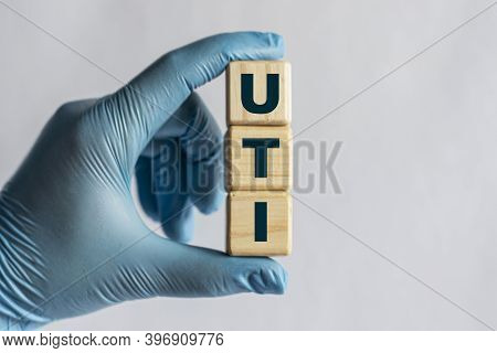 Uti (urinary Tract Infection) - Is An Acronym On Cubes Held By A Hand In A Blue Glove. Medical Conce