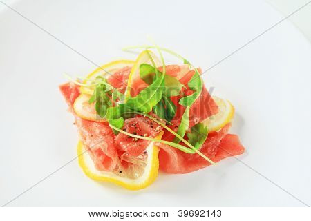 skivad skinka blandas med skivad citron och beströs med peppar