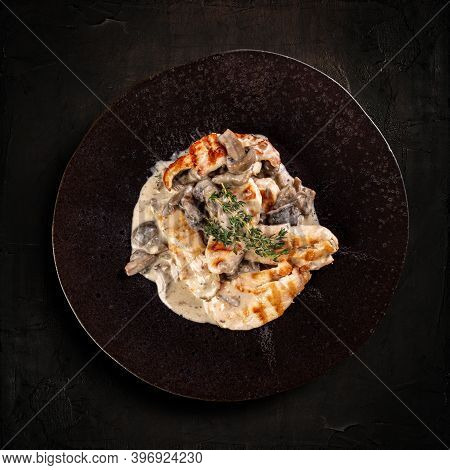 Chicken Grilled Breast Stewed In Cream Sauce With Mushrooms On Bark Background