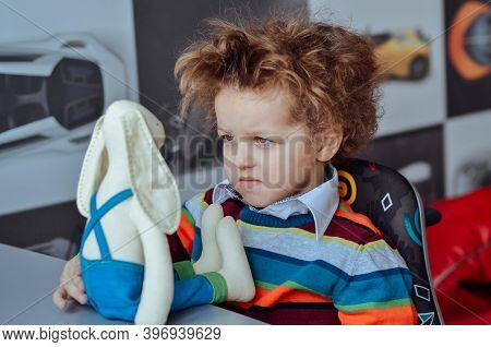 Funny Curly-haired Child Boy Expresses Funny Emotions Surprise Charismatic In A Sweater Black-and-wh