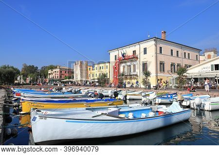 Bardolino, Italy - October 11:  The View Across Boats Moored In The Resort Town Of Bardolino To Cafe