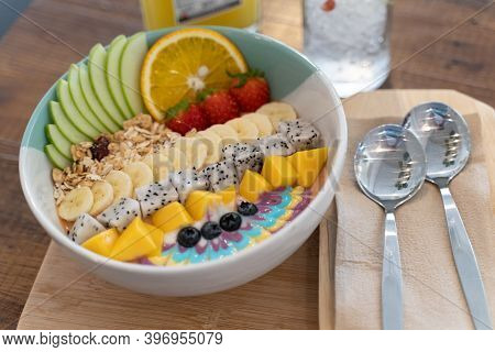 Healthy Smoothie Bowl Breakfast With Granola, Cut Banana, Sliced Apples, Strawberries, And Various T