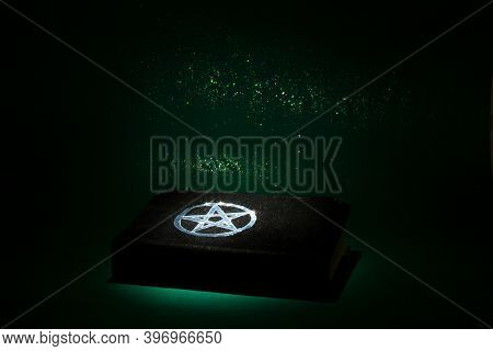 Black Magic Book On The Dark Green Background. Beautiful Occult Ritual. Spititual Mood.