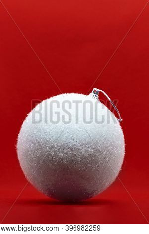 White And Furry Christmas Ball Over Red Background