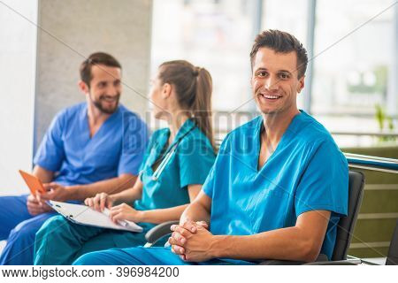Three Doctors Sitting Together And Talking During Changeover