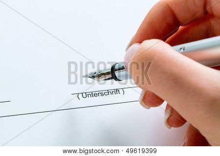 a hand with a fountain pen in the untrerschrift under a contract or testament.