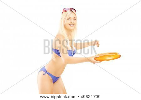 Smiling female in bikini playing with frisbee isolated on white background