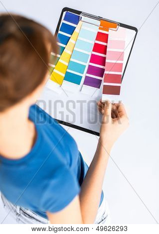 interior design and renovation concept - woman working with color samples for selection