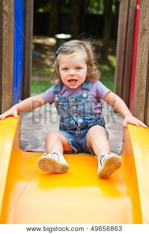 Happy Smiling Child  On Slide Playground Area