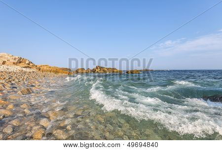 Ocean Waves Crashing Against A Pebble Shore