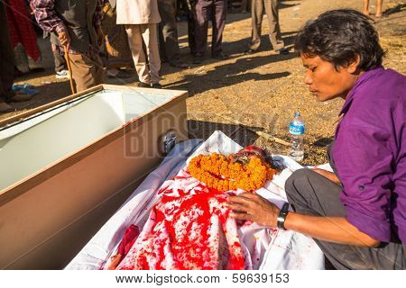 KATHMANDU, NEPAL - DEC 3, 2013: Unidentified local people during the cremation ceremony along the holy Bagmati River in Bhasmeshvar Ghat at Pashupatinath temple in Kathmandu.
