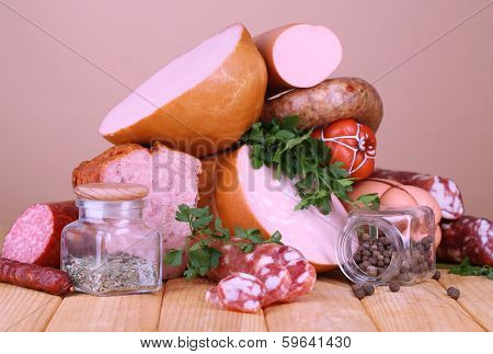 Lot of different sausages on wooden table on beige background