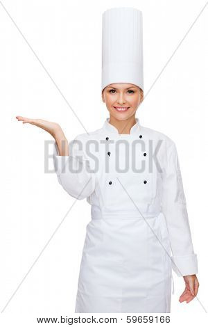 cooking, advertisement and food concept - smiling female chef holding something on palm of hand