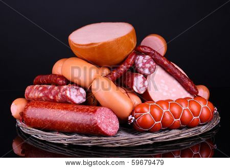 Lot of different sausages on black background