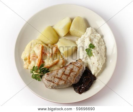 Veal sirloin steak with onion marmalade, celeriac puree, julienned carrots in a white sauce and boiled potatoes, garnished with parsley.