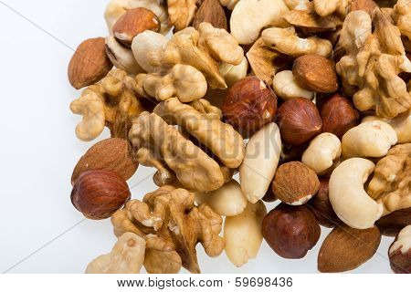 mixed nuts - hazelnuts walnuts cashews pine nuts isolated on white background