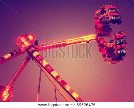 a fair ride shot with a long exposure at nigh toned with a grungy retro vintage instagram filter (grainy effect)