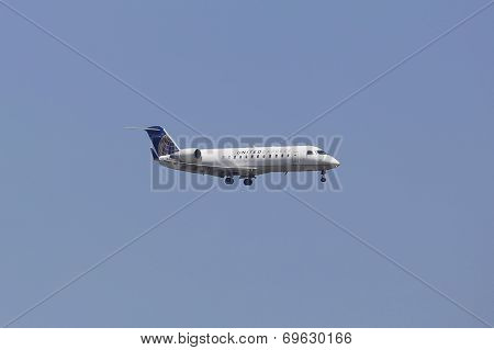 United Express Canadair CRJ-100 jet in New York sky before landing at JFK Airport